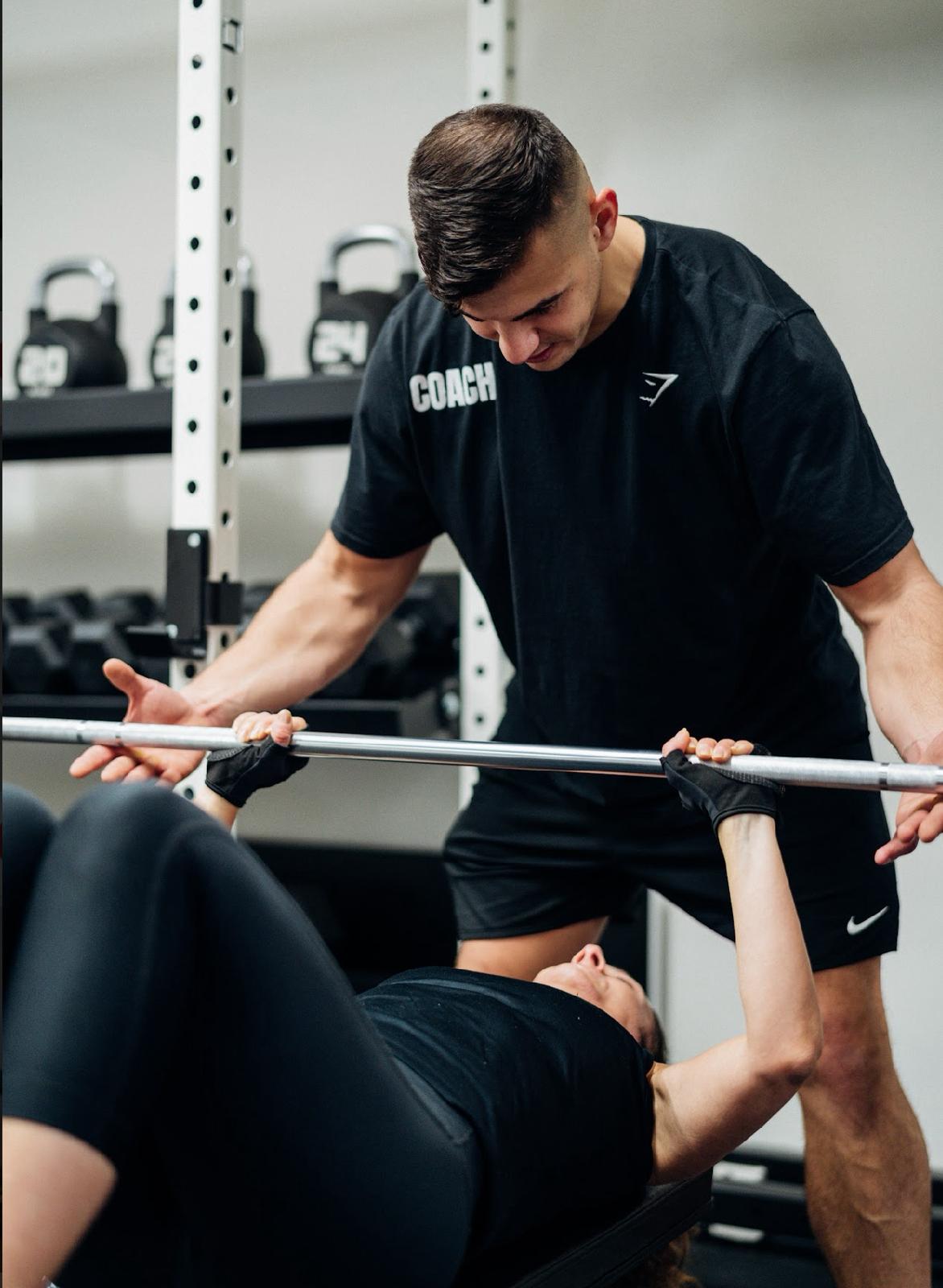 Coach spotting a lifter mid-set